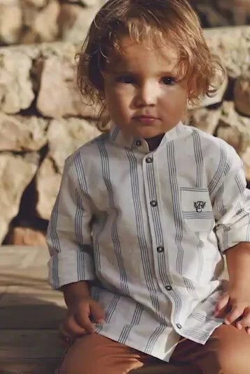 jeune garçon assis avec chemise rayée