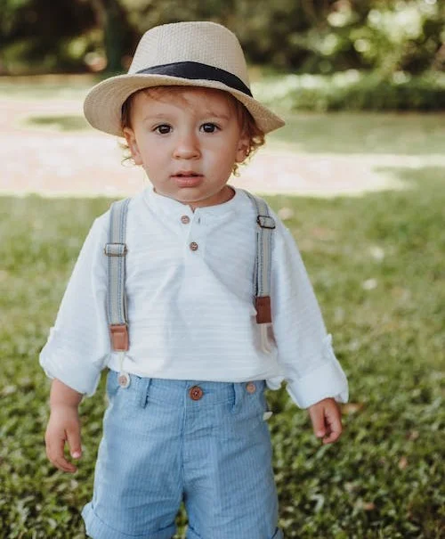 jeune garçon en salopette avec chapeau